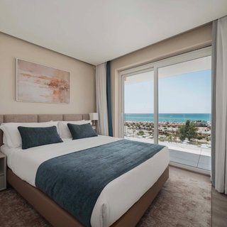 Quarto do Apartamento T1 com cama de casal e varanda vista mar